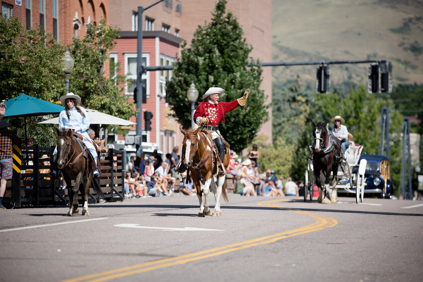 Barb and RD Melfi from White Fox Productions wave to everyone from their horses while they're dressed as Annie Oakley and Buffalo Bill during the Buffalo Bill Days parade.